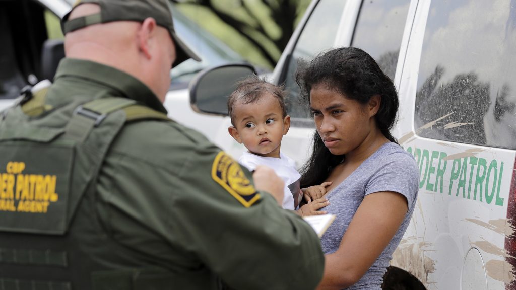 A mother migrating from Honduras holds her 1-year-old child as she surrenders to a U.S. Border Patrol agents after illegally crossing the border, near McAllen, Texas, in late June. A mother migrating from Honduras holds her 1-year-old child as she surrenders to a U.S. Border Patrol agents after illegally crossing the border, near McAllen, Texas, in late June.