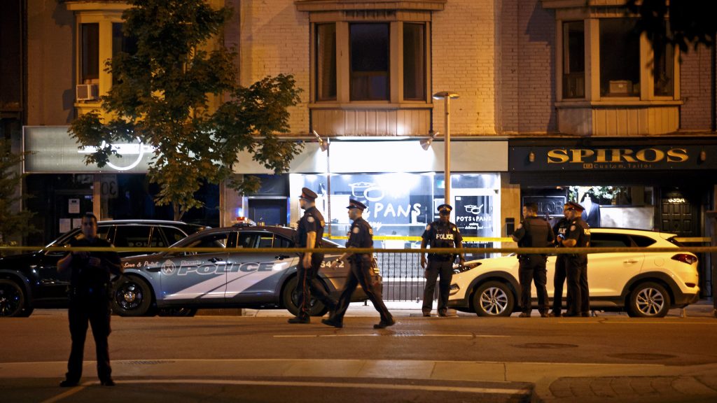 Police officers walk the scene in the Greektown neighborhood of Toronto Sunday night. Police say a gunman opened fire on 14 people in a restaurant. Three people are dead including the gunman, police reported. Police officers walk the scene in the Greektown neighborhood of Toronto Sunday night. Police say a gunman opened fire on 14 people in a restaurant. Three people are dead including the gunman, police reported. (Cole Burston/AFP/Getty Images)