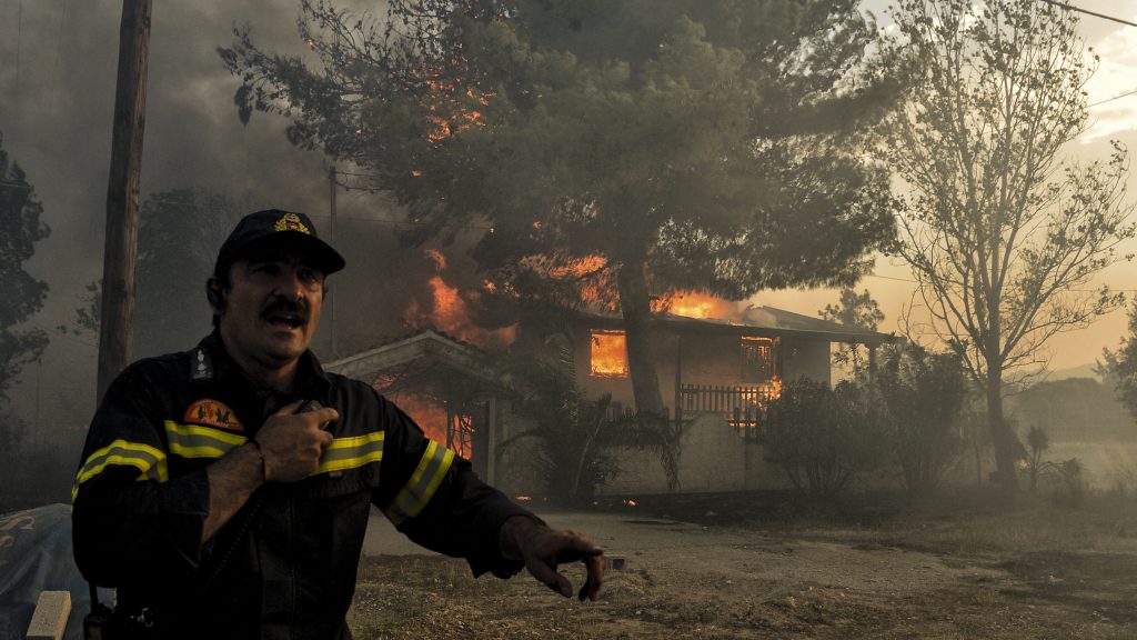 A firefighter next to a house burning during a wildfire in Kineta, near Athens, Greece, on Monday. Wildfires are not new to Greece but several blazes erupted especially quickly. A firefighter next to a house burning during a wildfire in Kineta, near Athens, Greece, on Monday. Wildfires are not new to Greece but several blazes erupted especially quickly. (Valerie Gache/AFP/Getty Images)