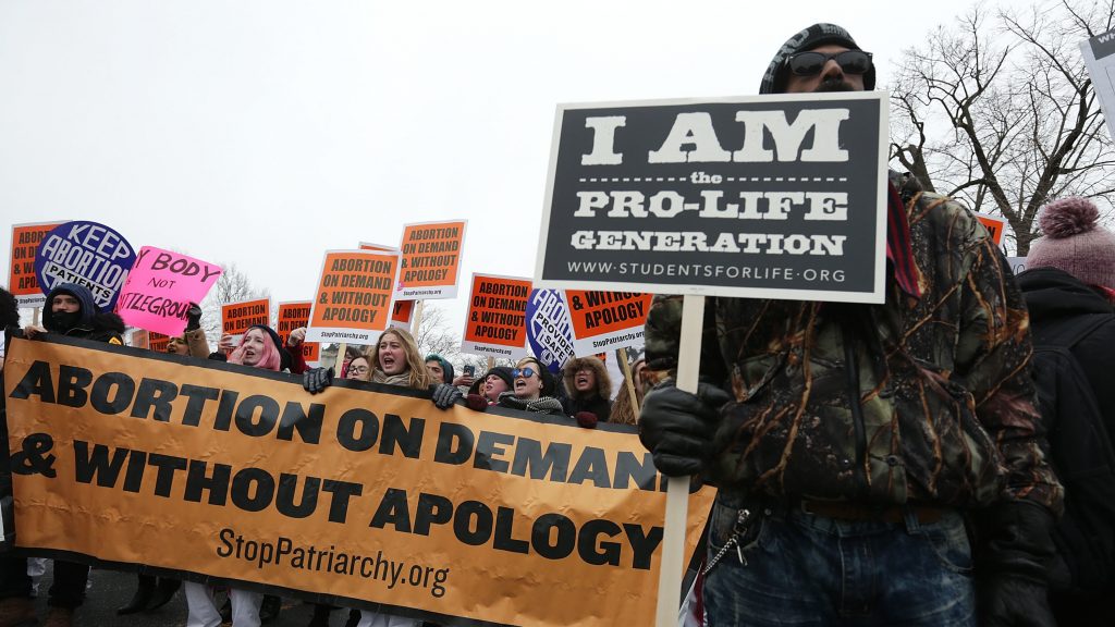 Protesters spread their dueling messages at a March for Life rally in 2016. Only 17 percent of Americans say they want the landmark Roe v. Wade ruling overturned, a new NPR/PBS NewsHour/Marist poll finds. Dueling protesters at a March for Life rally in 2016. Only 17 percent say they want the landmark Roe v. Wade ruling overturned, a new NPR/PBS NewsHour/Marist poll finds. (Alex Wong/Getty Images)