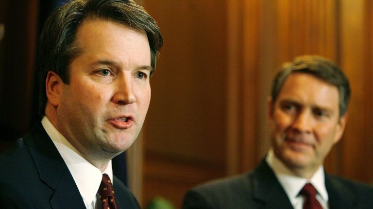 Brett Kavanaugh (left) speaks in 2006 when he was a nominee for the D.C. Circuit Court of Appeals. Then-Senate Majority Leader Bill Frist of Tennessee looks on. (Chip Somodevilla/Getty Images)