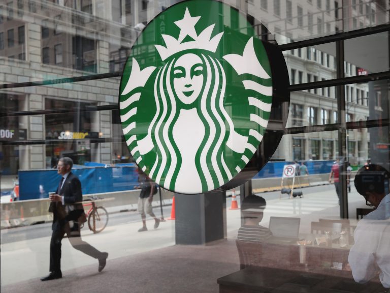 People walk by a Starbucks store in Chicago on May 29. Starbucks announced it plans on removing plastic straws from its 28,000 stores worldwide by 2020.