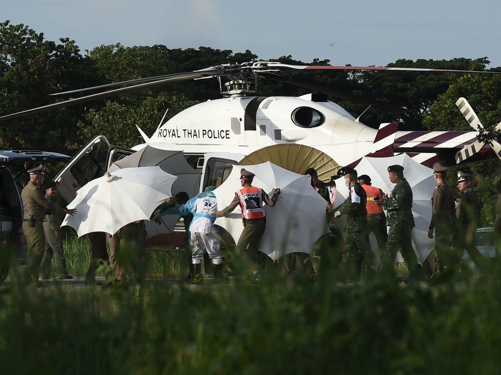 Police and military personnel use umbrellas to cover a stretcher as it is carried to a helicopter from an ambulance at a military airport in Chiang Rai, Thailand, on Monday, as rescue operations continue for those still trapped inside the cave in Khun Nam Nang Non Forest Park in the Mae Sai district. Police and military personnel use umbrellas to cover a stretcher as it is carried to a helicopter from an ambulance at a military airport in Chiang Rai, Thailand, on Monday, as rescue operations continue for those still trapped inside the cave in Khun Nam Nang Non Forest Park in the Mae Sai district.