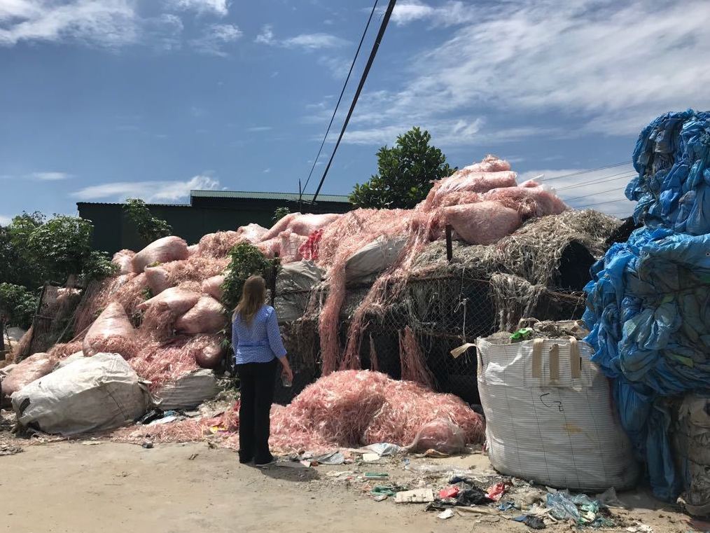 Waste engineer Jenna Jambeck of the University of Georgia surveys plastic waste in a southeast Asian village, where it will be recycled to make raw material for more plastic products. Jambeck advises Asian governments on how to keep plastic trash out of waterways. (Courtesy of Amy Brooks)