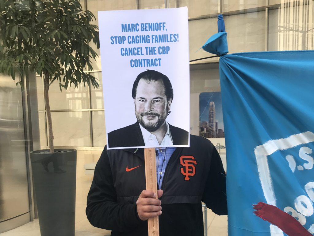 A protester holds up a sign targeting Salesforce CEO Marc Benioff outside the company’s headquarters in San Francisco on Monday. A protester holds up a sign targeting Salesforce CEO Marc Benioff outside the company's headquarters in San Francisco on Monday.
(Laura Sydell/NPR)