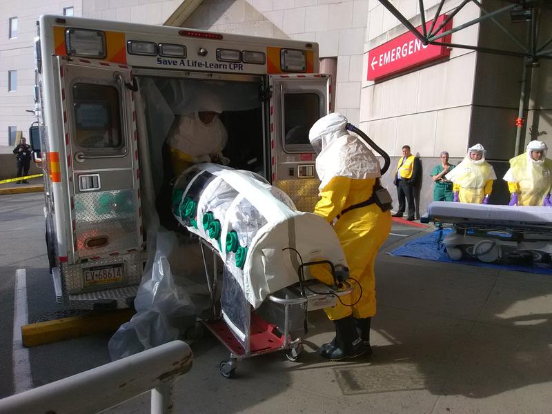 img_20180607_082717__1_ (1) EMTs unload Parag S. Gohel from an ambulance at UPMC Presbyterian's ER. Gohel is in an isolation pod because he’s pretending to have an infectious disease for the hospital’s yearly drill. (Sarah Boden/WESA)
