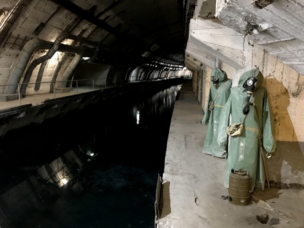 Hazmat suits hang next to the canal that leads from Balaklava Bay to the heart of the underground base. Hazmat suits hang next to the canal that leads from Balaklava Bay to the heart of the underground base. (Lucian Kim/NPR)