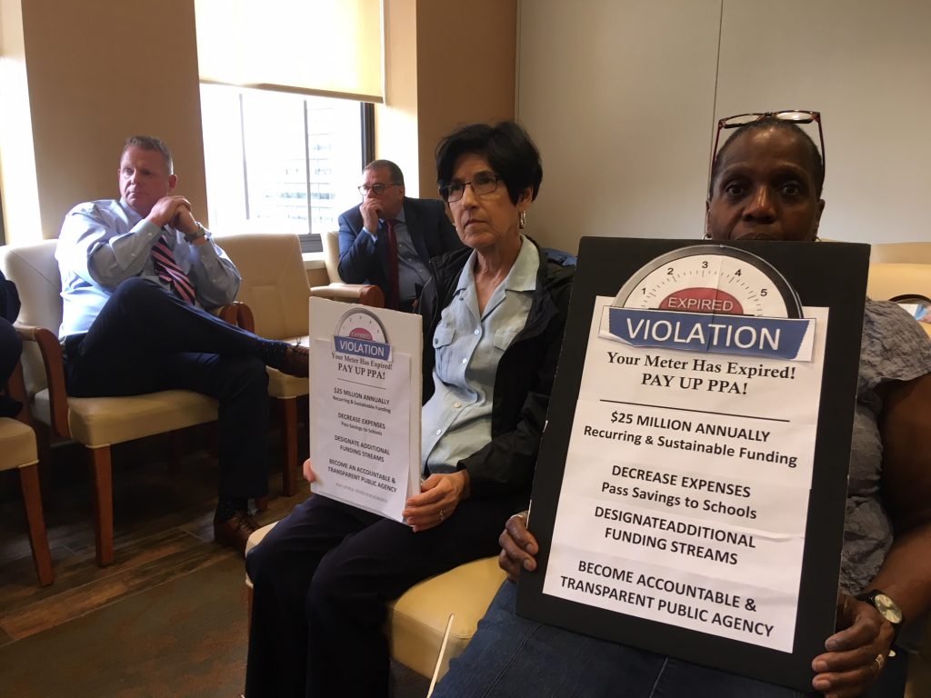Rochelle Nichols-Solomon (right) and other Pay Up PPA members demand more school funding at a PPA board meeting. (Jim Saksa/WHYY News) 