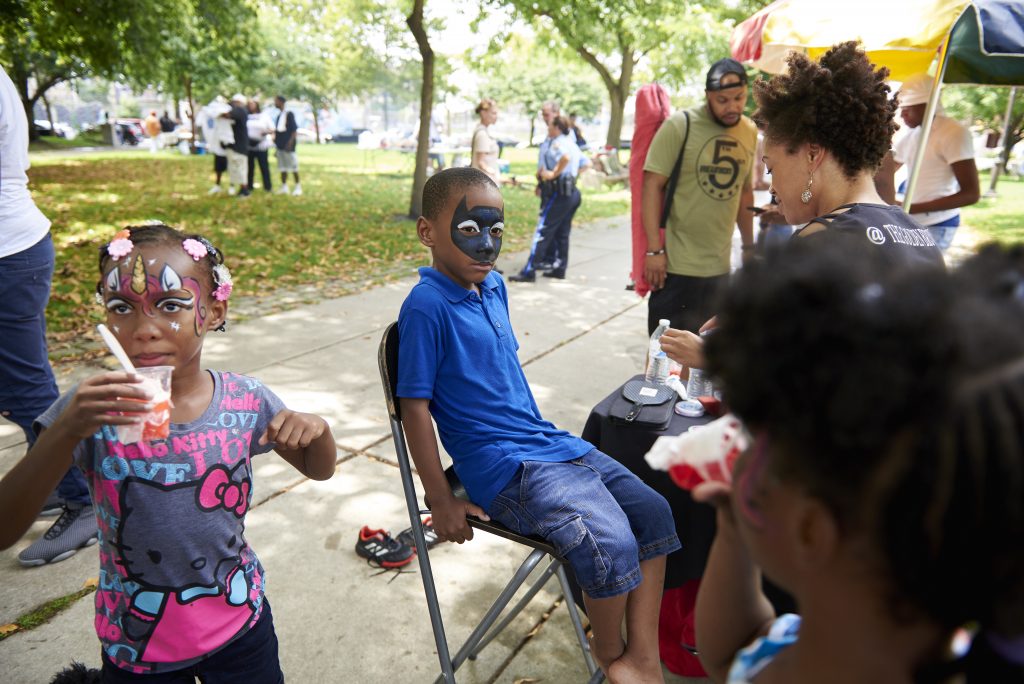 2018 08 04-n piserchio-quran-jefferson square park south philadephia-southwark projects reunion facepainting25 1 1 Quran, 6, of Southwest Philadelphia, has his face painted at the Southwark Projects Reunion at Jefferson Square Park by Latonia Brown, owner of Golden Brownie Art. (Natalie Piserchio for WHYY)