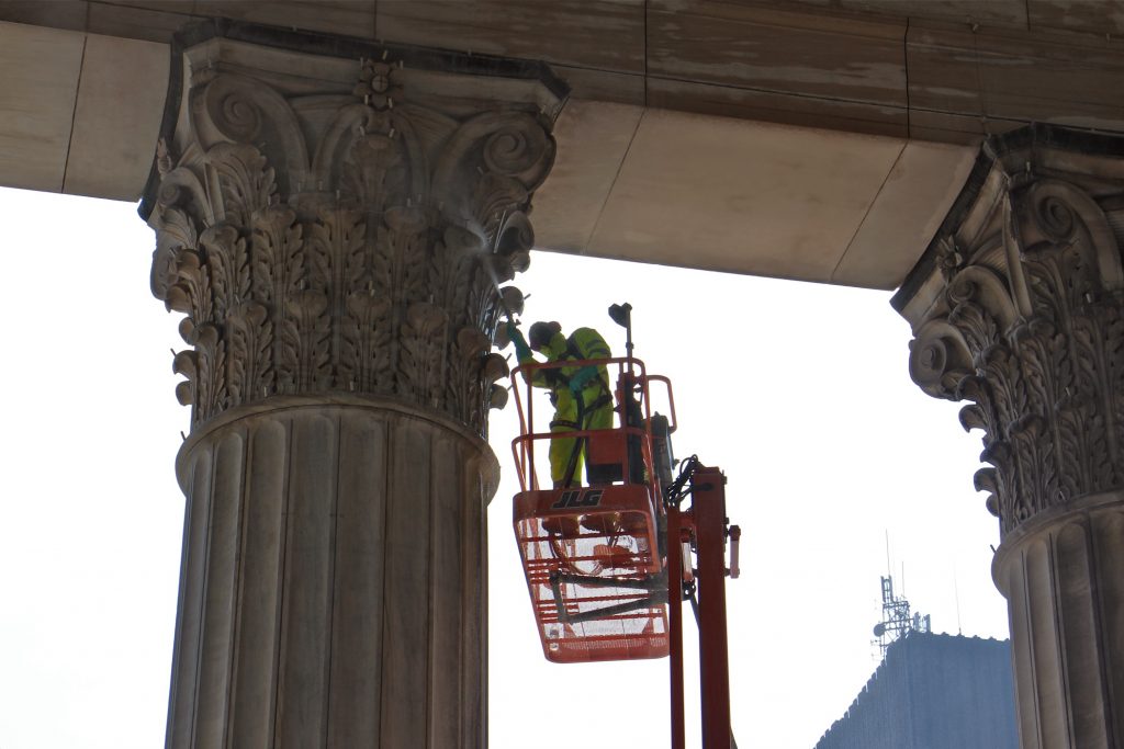 2018 08 07-e lee-30th street station-restoration east portico power wash column 1 A worker cleans the ornate limestone capitals of the East Portico at 30th Street Station. (Emma Lee/WHYY)