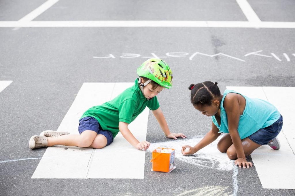 2018 08 11 – r wisniewski – geffen reinherz skyla car – philadelphia poplar and broad street – philly free streets Geffen Reinherz, 5 (left), and Skyla Car, 7, draw with chalk at Broad and Poplar Streets while Broad Street is closed off for Philly Free Streets on August 11, 2018. (Rachel Wisniewski for WHYY)