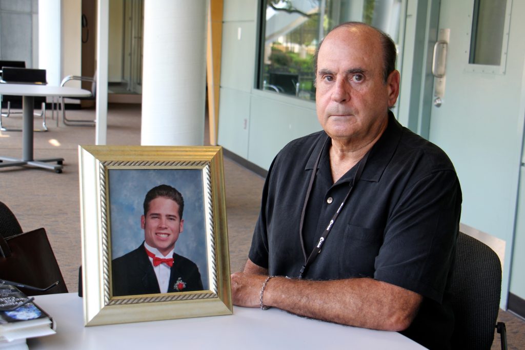 2018 08 15-e lee-arthur baselice-whyy-clergy child sex abuse Arthur Baselice Jr. poses with a photo of his son, Arthur Baselice III, who was abused by two Franciscan clergymen in Northeast Philadelphia. Baselice III died of a drug overdose in 2006 at age 28.