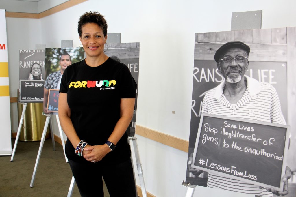 Sara Lomax-Reese, president and CEO of WURD Radio, presides over Founder's Day, which celebrates the legacy of her father, Philadelphia physician and entrepreneur Walter P. Lomax, Jr., who founded the radio station. She stands among posters created for WURD's Transmit/Transform multimedia project aimed at stopping violence.