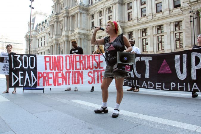 Sam Sitrin of ACT UP helps lead a protest of about 30 people calling for an overdose prevention site in Philadelphia. (Emma Lee/WHYY)