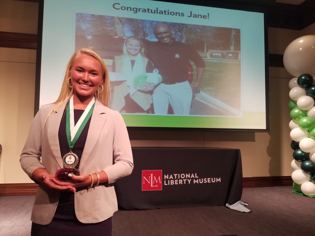 20180809_124921-1 Jane Lyons, with both her Young Hero Award around her neck, and holding her Spark Award, acknowledging her work helping incarcerated youth. (Peter Crimmins/WHYY)