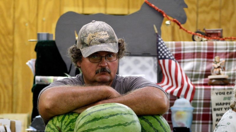 A vendor rests his arms on the melons at a produce stand at Zern's Farmers Market in Gilbertsville, Pa. (Bastiaan Slabbers for WHYY)