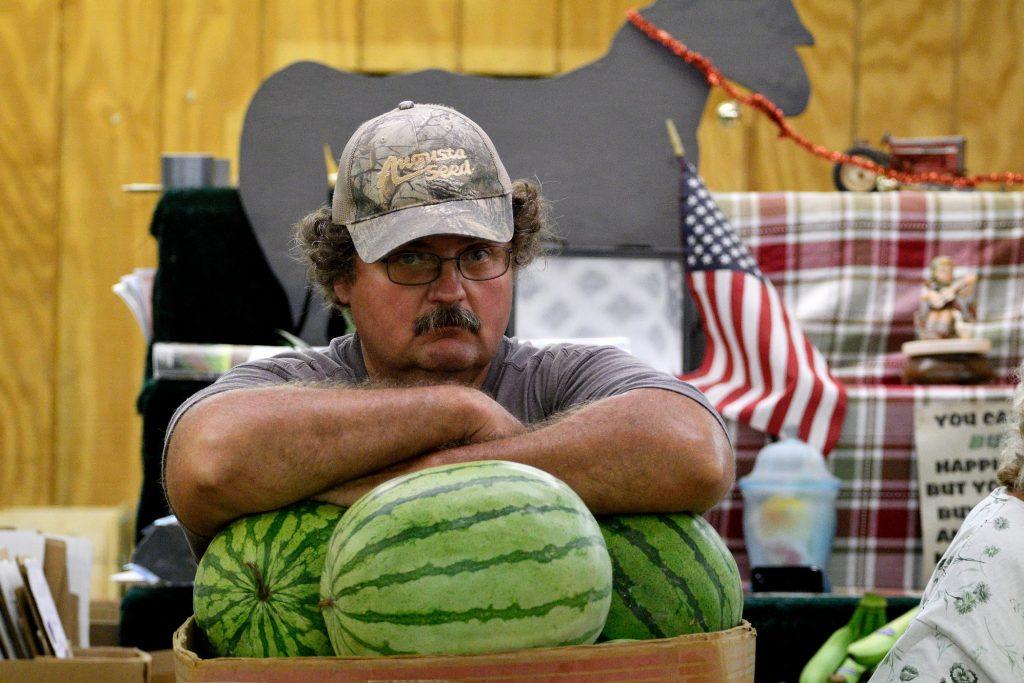 20180824_Zerns_Closing_BS1484 A vendor rests his arms on the melons at a produce stand at Zern's Farmers Market in Gilberstville, Pa.