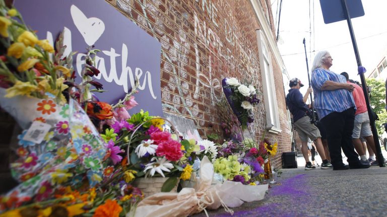 A memorial to Heather Heyer — who was killed at a Charlottesville rally by a driver facing murder and hate crime charges — stands at the site of her death. Heyer's mother, Susan Bro, is in the background. (Steve Helber/AP)