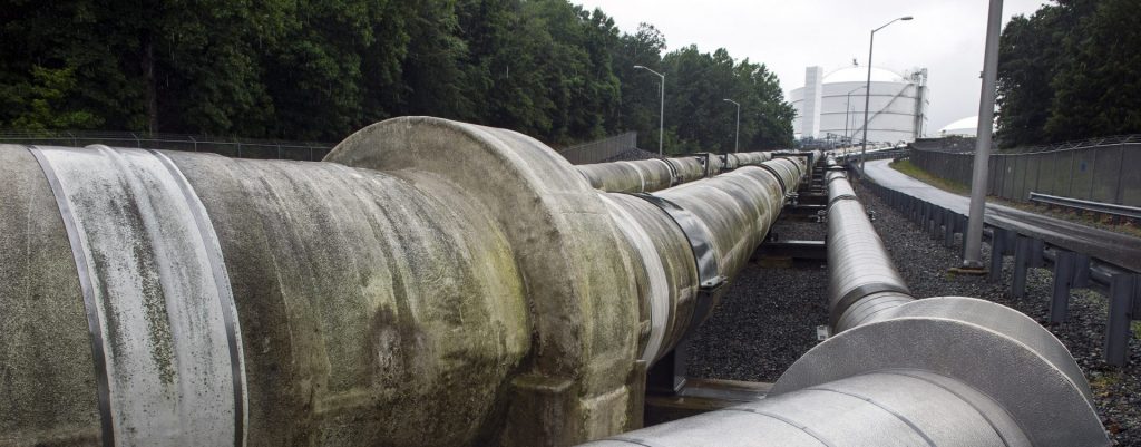 Transfer pipes carry liquified natural gas to and from a holding tank, seen in background, at Dominion Energy's Cove Point LNG Terminal in Lusby, Md., Thursday, June 12, 2014. (Cliff Owen/The Associated Press)