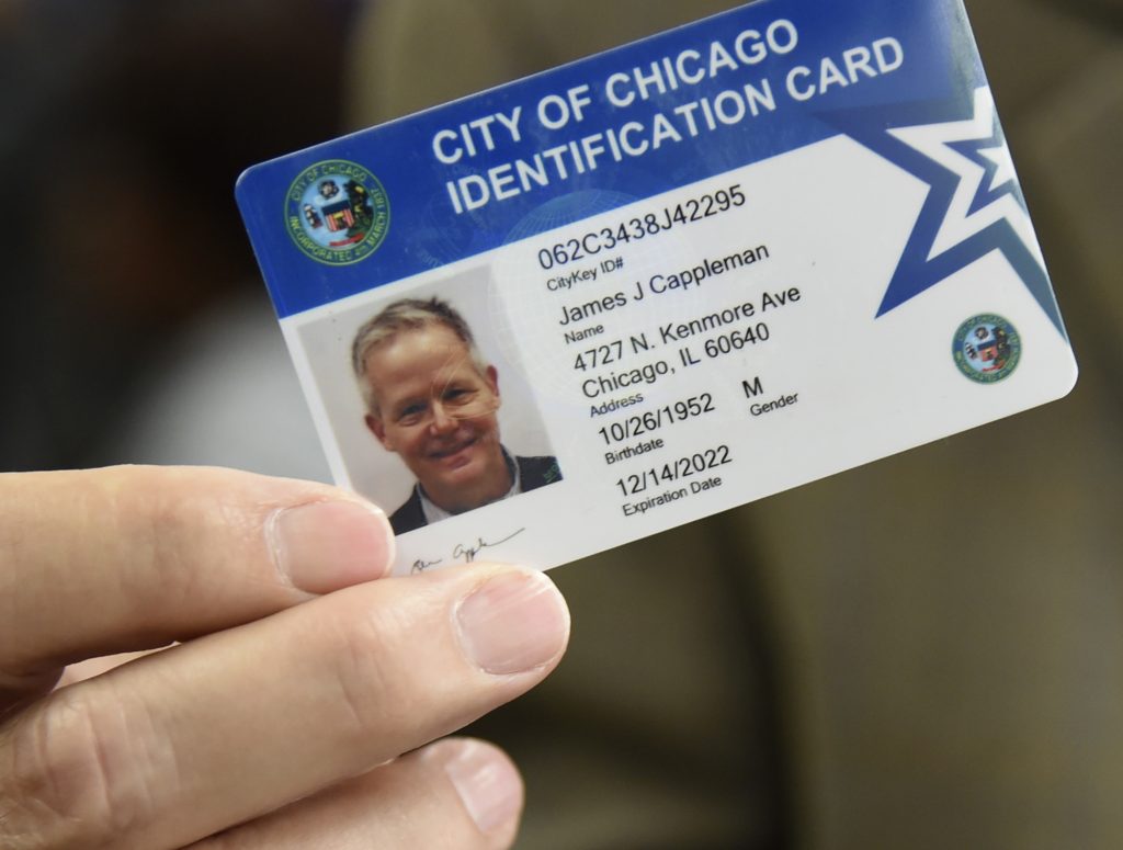 Chicago ID Cards Alderman James Cappleman holds his CityKey ID card, Friday, June 8, 2018, in Chicago. The city of Chicago is sending out staffers into various communities to get the municipal ID cards into the hands of undocumented immigrants, homeless people, senior citizens and others who often find it hard to obtain a valid form of identification. Officials hope that in a couple of years more than 100,000 Chicago residents will have the cards that can be used to register to vote and do things like check out a book from the library. (AP Photo/Annie Rice)