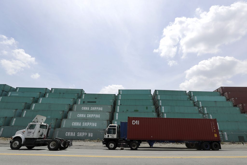 China Tariffs FILE- In this June 29, 2017, file photo containers are stacked up in Elizabeth, N.J., as a truck drives by at Port of Elizabeth. The U.S. has threatened to impose 25 percent duties on $34 billion in Chinese products starting Friday, July 6, 2018, and China has said it will fire back with corresponding tariffs. (AP Photo/Julio Cortez, File)