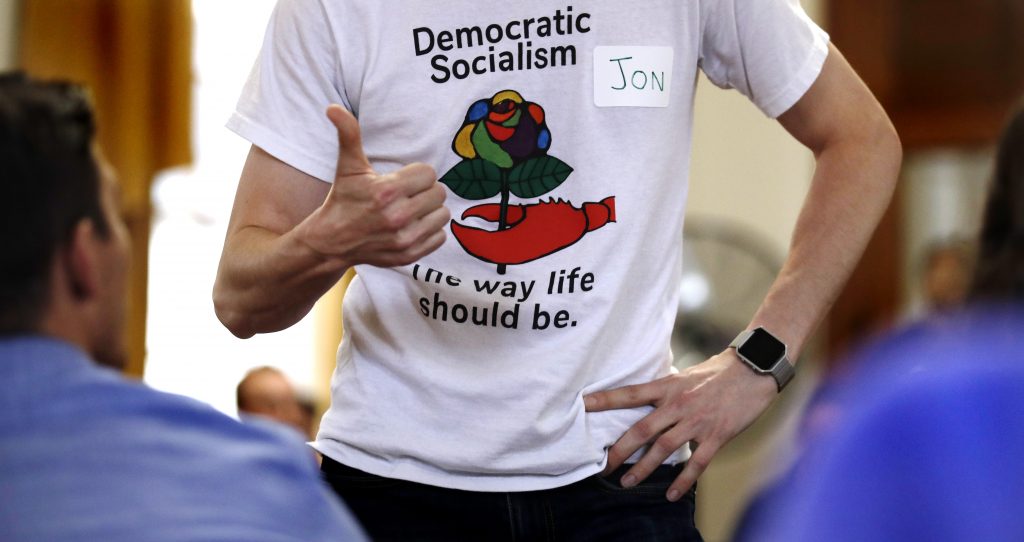 Jon Torsch Jon Torsch, center, wears a t-shirt promoting democratic socialism during a gathering of the Southern Maine Democratic Socialists of America at City Hall in Portland, Maine, Monday, July 16, 2018. On the ground in dozens of states, there is new evidence that democratic socialism is taking hold as a significant force in Democratic politics. (AP Photo/Charles Krupa)