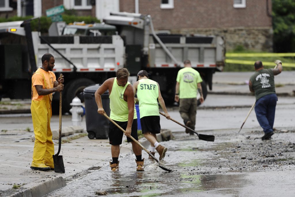 Severe Weather Pennsylvania Flooding Workers clean up debris swept into the street during flooding in Upper Darby, Pa., Monday, Aug. 13, 2018. Authorities say heavy rains have been causing flooding and prompting road closures and rescues of people from stranded cars in central and southeastern Pennsylvania. (AP Photo/Matt Rourke)