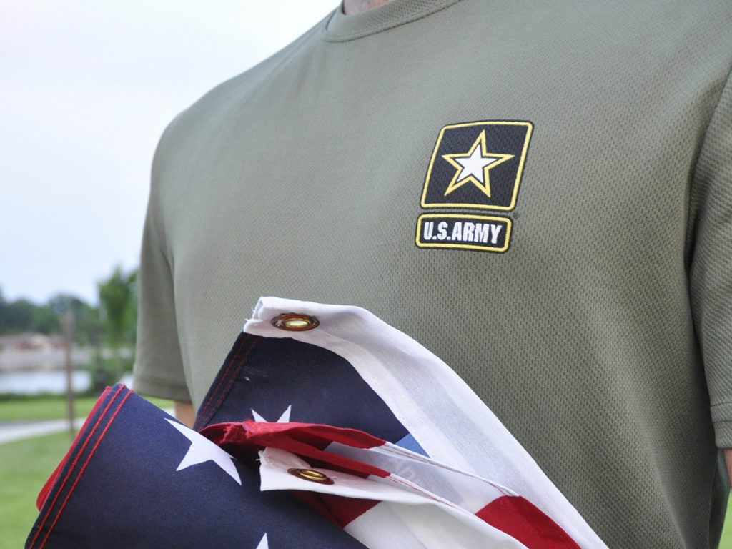 In this Tuesday, July 3, 2018, photo, a Pakistani recruit, 22, who was recently discharged from the U.S. Army, holds an American flag as he poses for a picture. The Army said in court documents it has reinstated more than 30 immigrant recruits and reservists whose contracts had been terminated. (Mike Knaak/AP)