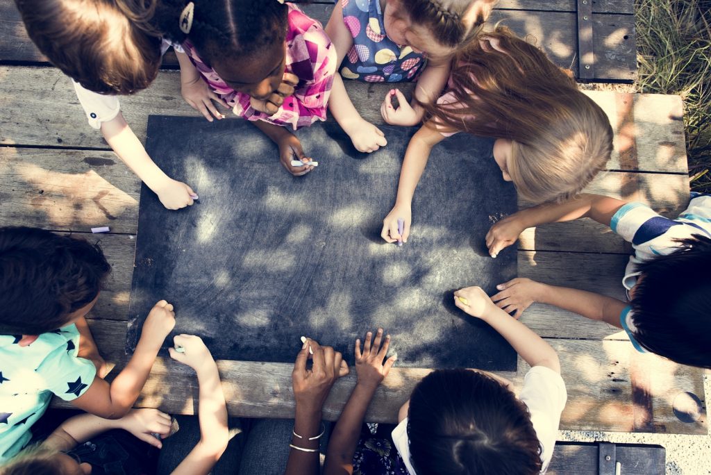 Group of Diverse Kids Drawing on Chalkboard Together Kids drawing on a chalkboard. (Photo Courtesy/Bigstock)