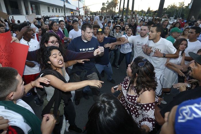 Protesters surround a Trump supporter on S. Almaden Boulevard outside the San Jose Convention Center as Presidential candidate Donald Trump holds a rally in San Jose, Calif., Thursday, June 2, 2016. (Patrick Tehan/Bay Area News Group Archives)