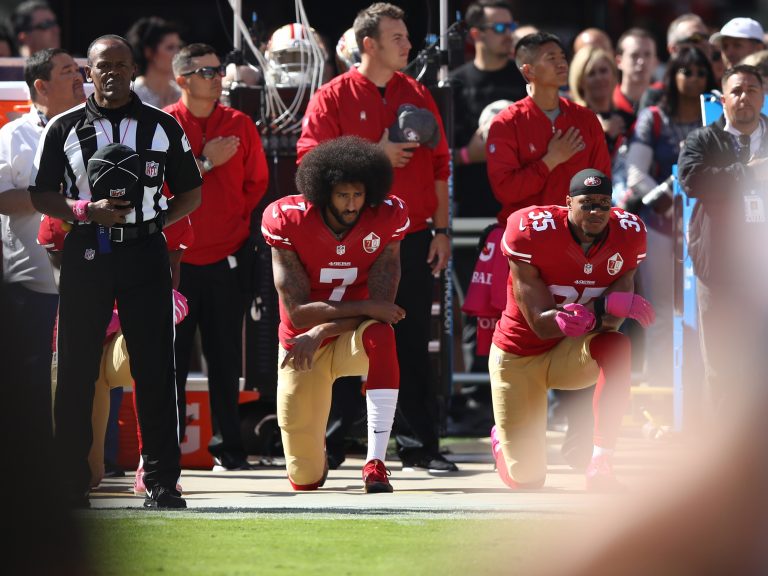 Colin Kaepernick, seen kneeling beside teammate Eric Reid during the national anthem before a game in 2016, catalyzed a series of protests against police brutality that continue to roil the NFL. (Ezra Shaw/Getty Images)