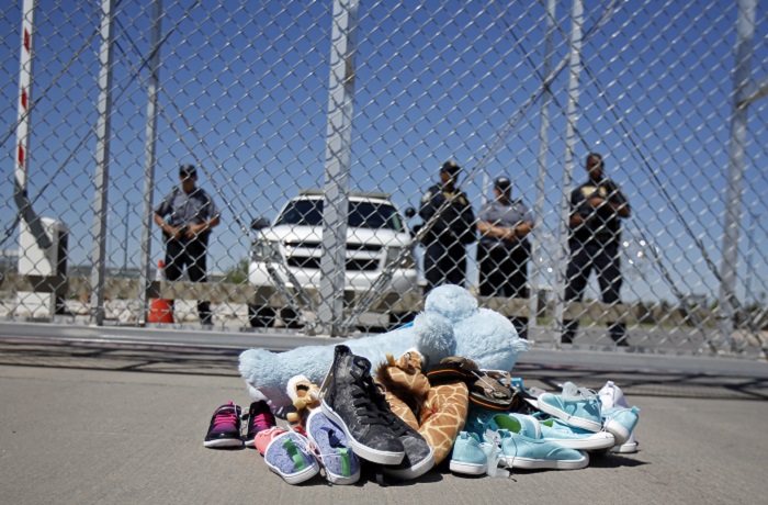Immigration US Mayors Shoes and a teddy bear, brought by a group of U.S. mayors, are piled up outside a holding facility for immigrant children in Tornillo, Texas, near the Mexican border, Thursday, June 21, 2018. Mayors from more than a dozen U.S. cities including New York and Los Angeles gathered near the holding facility to call for the immediate reunification of immigrant children with their families. (AP Photo/Andres Leighton)