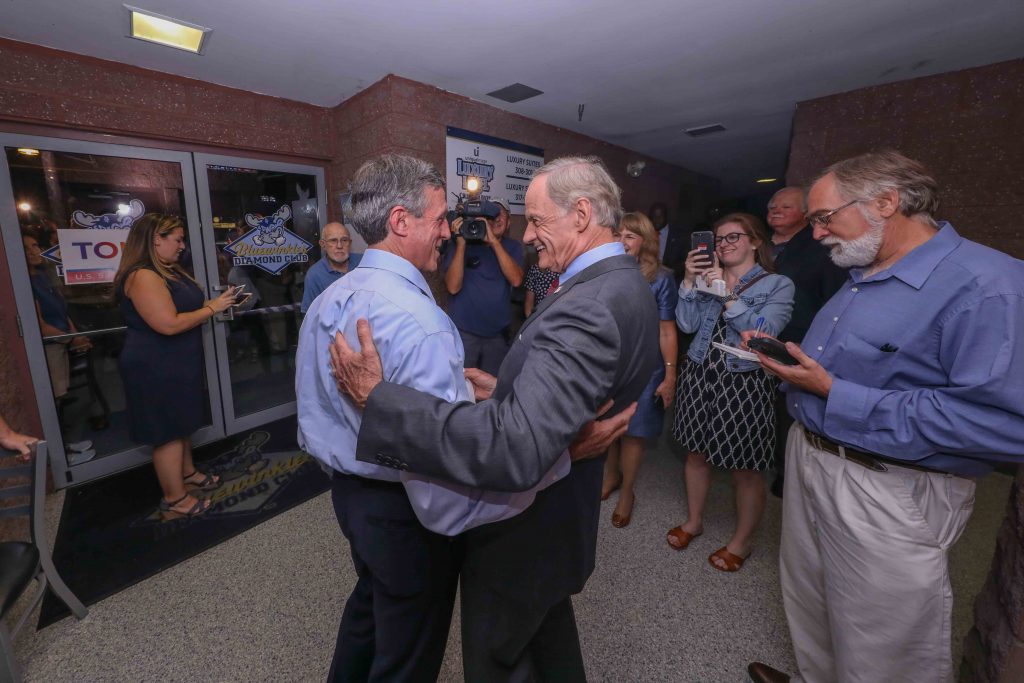 United States Senator Tom Carper and his staff as well as supporters gathered to watch the election results roll in United States Senator Tom Carper (right) greets Governor John Carney during a Primary Election gathering Thursday, Sept. 06, 2018, at Frawley Stadium in Wilmington, Delaware. (Saquan Stimpson/for WHYY)