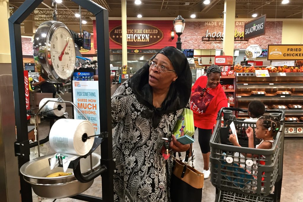 2018 09 07-a wolfman arent-southwest philadelphia island avenue shoprite-talk it up learning April Ellis weighs some bananas at the Island Avenue Shoprite in Southwest Philadelphia while shopping with her grandchildren, Kalanni and Shareef. (Avi Wolfman-Arent/WHYY)