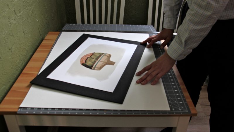 Steve Garguilo mounts a print by Mexican artist Ruth Zehntner. (Emma Lee/WHYY)