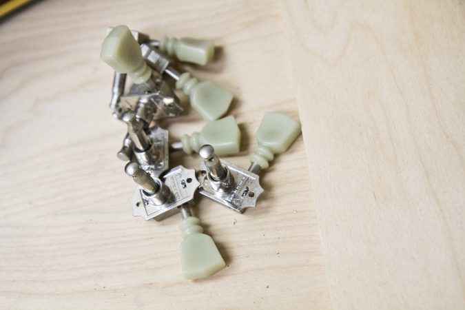 Tuning pegs of a disassembled guitar at Superior Guitar Works in Flourtown.(Kimberly Paynter/WHYY)