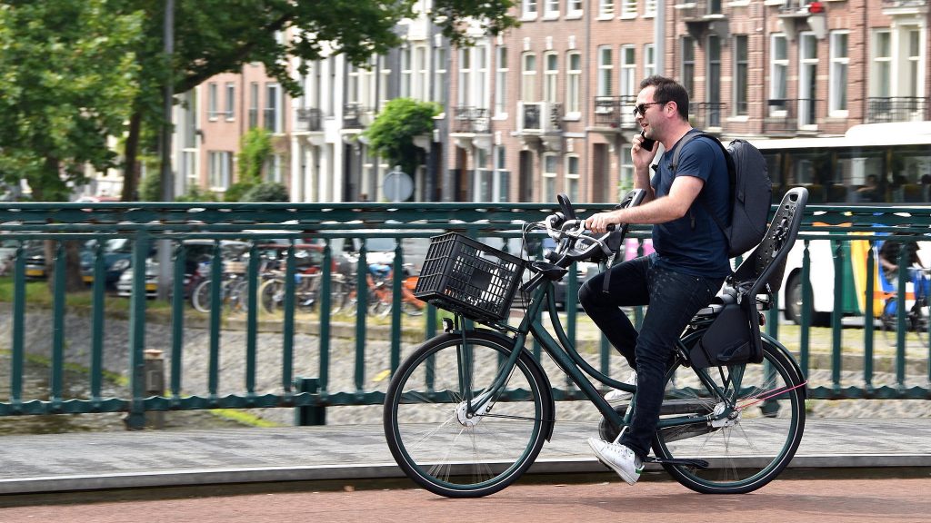 A man talks on the phone while he rides a bike in Amsterdam. Legislation proposed in the Netherlands would impose a fine on bicyclists who use a mobile phone while they’re on their bikes. A man talks on the phone while he rides a bike in Amsterdam. Legislation proposed in the Netherlands would impose a fine on bicyclists who use a mobile phone while they're on their bikes.
(FaceMePLS/Flickr)
