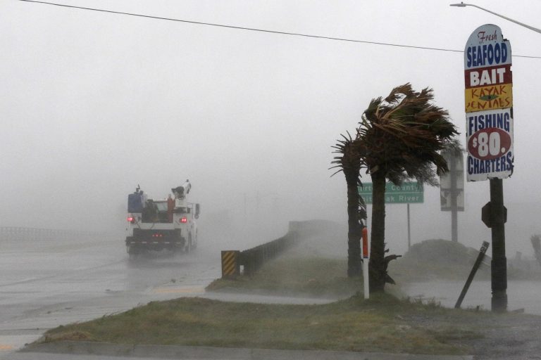 A work truck drives on Hwy 24 as the wind from Hurricane Florence blows palm trees in Swansboro N.C., Thursday, Sept. 13, 2018. (Tom Copeland/AP Photo)