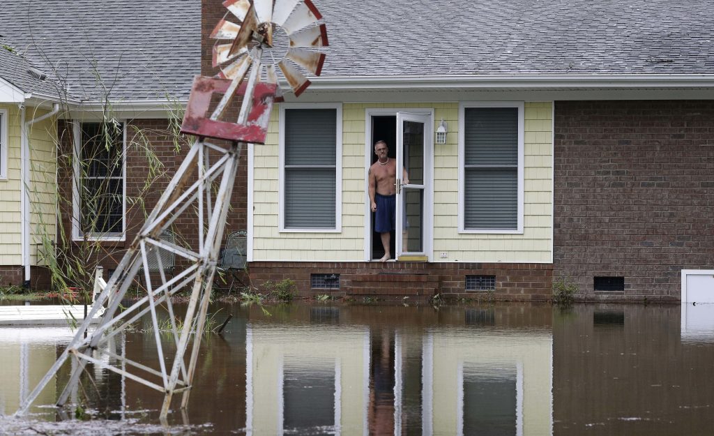 APTOPIX Tropical Weather North Carolina A man peers from his flooded home in Lumberton, N.C., Sunday, Sept. 16, 2018, in the aftermath of Hurricane Florence. (AP Photo/Gerry Broome)