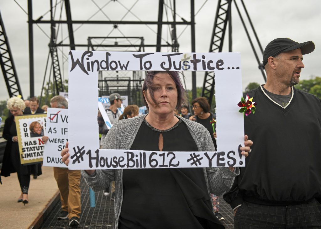 Clergy Abuse Civil Lawsuits Kelly Williams carries a sign voicing support for legislation that would change the statute of limitations for child sex crimes, during a march in Harrisburg, Pa., Monday, Sept. 24, 2018. At right is her husband Brent. A proposal to give victims of child sexual abuse a two-year window to sue over allegations that would otherwise be too old to pursue was overwhelmingly approved by the state House on Monday, as supporters cheered from the gallery. (Steve Mellon/Pittsburgh Post-Gazette via AP)