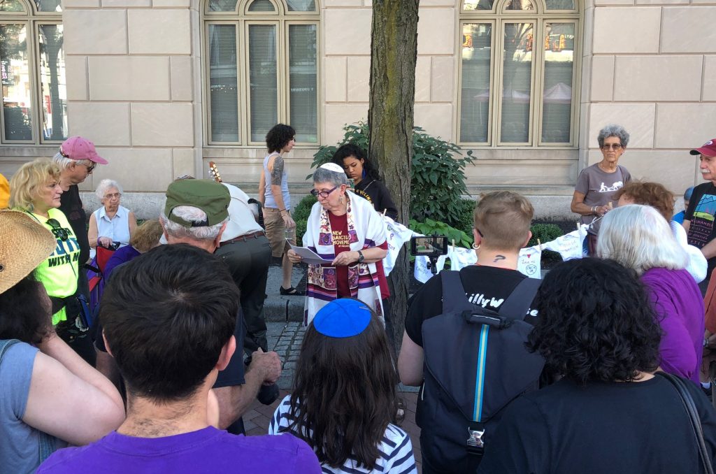 IMG_1701 Rabbi Linda Holtzman, center, led a Tashlich ceremony in front of the U.S. Immigration and Customs Enforcement office on Chestnut Street in Philadelphia. (Darryl C. Murphy for WHYY)