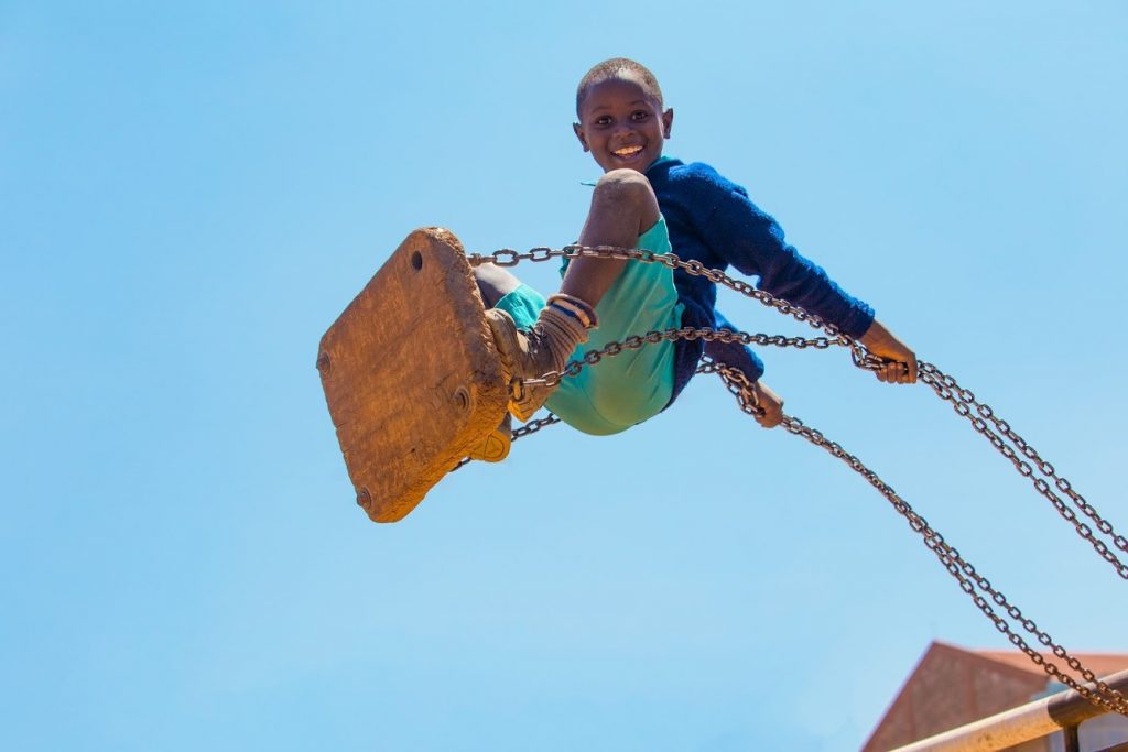 Mwarv – Boy-on-Swing-1 In a work by Kenyan photographer Mwarv Kirubi, a pupil from St. Martin's School Kibagare plays on the swings at break time on 27th January 2017. It is one of 98 works included in