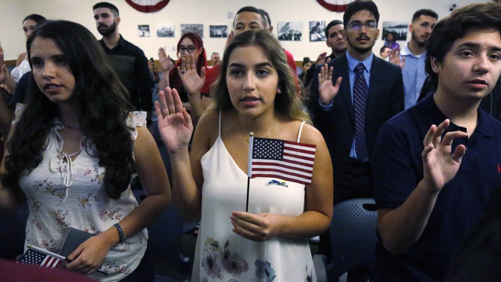 Ericka Ames, center, of Nicaragua recites the Oath of Allegiance during a naturalization ceremony at the U.S. Citizenship and Immigration Services in Miami. The backlog of citizenship applications has increased dramatically under the Trump administration. Ericka Ames, center, of Nicaragua recites the Oath of Allegiance during a naturalization ceremony at the U.S. Citizenship and Immigration Services in Miami. The backlog of citizenship applications has increased dramatically under the Trump administration. (Wilfredo Lee/AP)