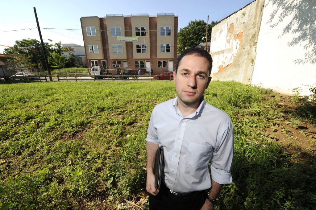 PDelinquint31-gg Ori Feibush, owner of ocfrealty in Philadelphia, stands on vacant lots on the 1700 block of Manton St in Point Breeze across the street from four 3-story townhouses his company built and is selling (Clem Murray/Inquirer)