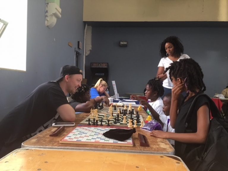 Volunteers teach young kids to play chess at the After School Activities Fair at Francis Myers Reaction Center in Southwest Philly on September 21, 2018. (Taylor Allen/WHYY)