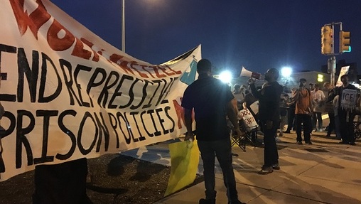 Dozens of protesters gather on a Philadelphia street corner to urge Governor Tom Wolf to change a number of new prison security measures. (Katie Meyer/WITF)