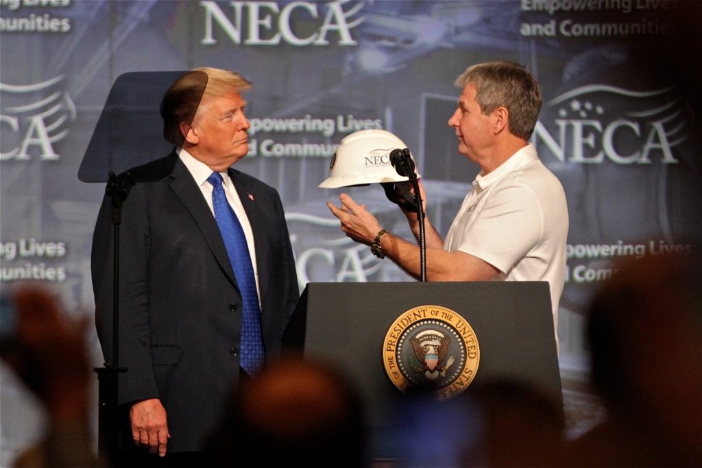 2018 010 02-e lee-donald trump david long-philadelphia convention center-speech electrical contractors President Donald Trump accepts a hard hat from National Electrical Contractors Association President David Long. Trump closed the NECA convention in Philadelphia with a speech on job creation and training. (Emma Lee/WHYY)