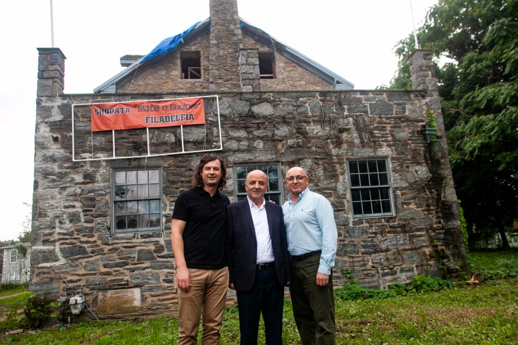 Lead architect Lluka Lakuriqi, left, Tajar Domi, center and Bujar Gjoka of the Albanian American Association are seen outside of the historic Lower Dublin Academy in Northeast Philadelphia. (Brad Larrison for WHYY)