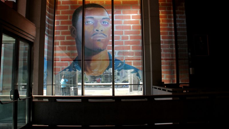 The first floor of the Municipal Services Building is wrapped with the portraits of 17 formerly incarcerated young men and women as part of the Mural Arts 