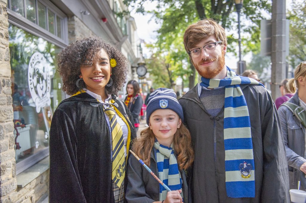 Wizards for a day (from left) Charlene Delos Santos, Harley Birkmire, and Joe Birkmire, show off their attire on Germantown Avenue at the Chestnut Hill Witches and Wizards Festival. (Jonathan Wilson for WHYY)